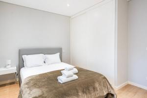 a bedroom with a bed with towels on it at GuestReady - Ideal Getaway minutes from Porto in Gondomar