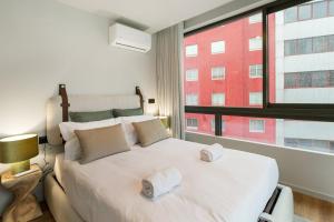 a bedroom with a large bed with two towels on it at GuestReady - Grey Roof in Vila Nova de Gaia in Santo Ovídio