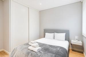 a bedroom with a bed with towels on it at GuestReady - Ideal Getaway minutes from Porto in Gondomar