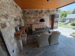 sala de estar con sillas, mesa y pared de piedra en Stone House, en Bodrum City