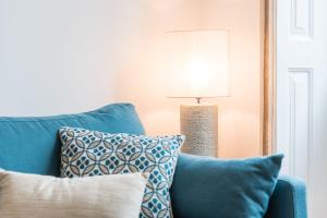 un divano blu con cuscini accanto a una lampada di GuestReady - Chakra Duplex a Porto