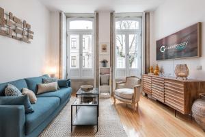 un soggiorno con divano blu e TV di GuestReady - Chakra Duplex a Porto