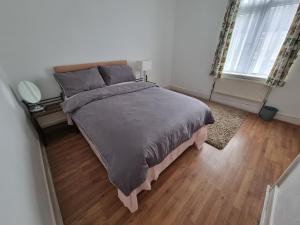 1 dormitorio con 1 cama grande y suelo de madera en ilford town house, en Ilford