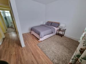 1 dormitorio con cama y alfombra en ilford town house, en Ilford