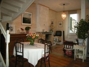 une salle à manger avec une table et un vase de fleurs. dans l'établissement La Maison sur la Colline, à Mauroux