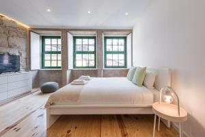una camera bianca con un grande letto e finestre di GuestReady - Mezuzah Yellow a Porto