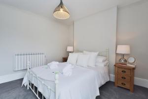 - une chambre blanche avec un lit blanc et une table dans l'établissement Marsden House Apartment 3, à Whitchurch
