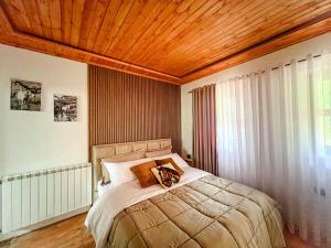 a bedroom with a large bed with a wooden ceiling at Logu i Harushave in Theth
