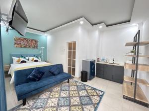 a bedroom with a bed and a blue couch at Sunnydays homestay in Jepara