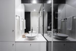 uma casa de banho em preto e branco com 2 lavatórios e um chuveiro em GuestReady - The Other Side no Porto