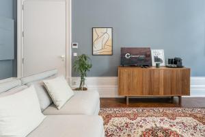 a living room with a couch and a tv on a cabinet at GuestReady - Well furnished studio in Porto. in Porto