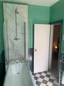 a bathroom with a tub with a marble wall at Leven House Bed and Breakfast in Crieff