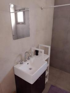 uma casa de banho com um lavatório branco e um espelho. em S4 Hermoso departamento para conocer Mendoza em Godoy Cruz
