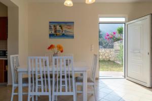 a white dining room with a white table and chairs at Villa Sunlights Bali in Balíon