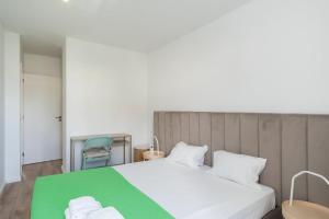 1 dormitorio con 1 cama blanca grande con manta verde en GuestReady - Valbom Douro View, en Valbom