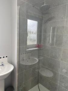 uma casa de banho com um chuveiro e um lavatório. em 41 Larchwood Drive Holiday Home em Inverness