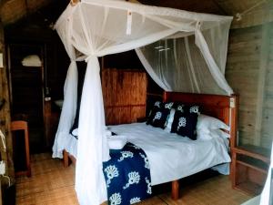 a bedroom with a bed with a canopy at Utshwayelo Kosi Bay Mouth Lodge & Camp in Manguzi