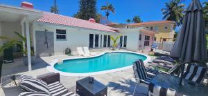 - une piscine avec des chaises et une maison dans l'établissement Grand Pool 4 BEDS 4 BATHS Villa Close to Beach!, à Hollywood