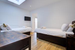 Spacious Bedroom Ensuite with 2 Single Beds - Room 3 في برنتوود: غرفة معيشة بها سريرين وتلفزيون