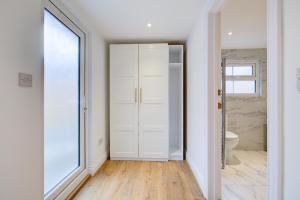 Spacious Bedroom Ensuite with 2 Single Beds - Room 3 في برنتوود: حمام بدولاب أبيض ومرحاض