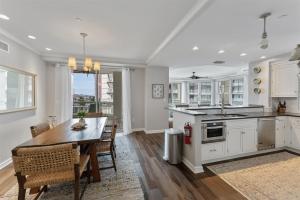 a kitchen with white cabinets and a table and chairs at Residence 102 At The Grand in Wildwood