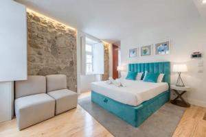 ein Schlafzimmer mit einem Kingsize-Bett und einem Sofa in der Unterkunft GuestReady - The New Yellow Ledbetter in Porto