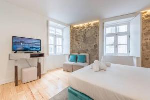 ein Schlafzimmer mit einem großen Bett und einem TV in der Unterkunft GuestReady - The New Yellow Ledbetter in Porto