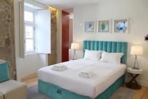 Schlafzimmer mit einem großen Bett mit blauem Kopfteil in der Unterkunft GuestReady - The New Yellow Ledbetter in Porto