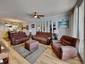 sala de estar con muebles de cuero y ventilador de techo en The Pearl of Navarre #702, en Navarre