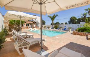 Un patio con sillas y sombrilla y una piscina. en Gorgeous Home In Terrasini, en Terrasini