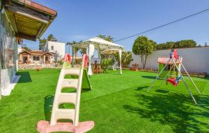 un jardin avec une aire de jeux dotée d'un toboggan et de balançoires dans l'établissement Beautiful Home In Terrasini With Outdoor Swimming Pool, à Terrasini
