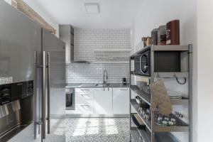 cocina con armarios blancos y nevera de acero inoxidable en GuestReady - Modern Duplex, Neo-Classical Building en Oporto