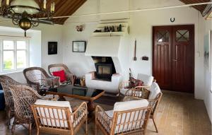 - un salon avec des chaises en osier et une cheminée dans l'établissement Cozy Home In Sankt Ibb With Kitchen, à Sankt Ibb