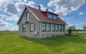 una casa con techo rojo en un campo verde en Cozy Home In Sankt Ibb With Kitchen en Sankt Ibb