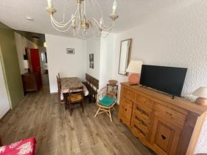 a living room with a flat screen tv on a wooden dresser at Appartement Les Adrets-Prapoutel, 2 pièces, 5 personnes - FR-1-557-105 in Les Adrets