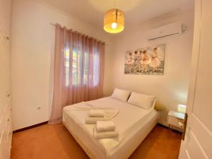 um quarto com uma cama branca e toalhas em Corfu Dream Holidays Villas em Kanoni