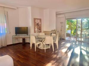 uma sala de estar com uma mesa e cadeiras e uma televisão em Corfu Dream Holidays Villas em Kanoni