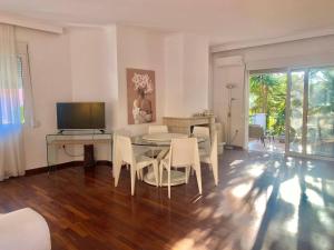 a living room with a table and chairs and a television at Corfu Dream Holidays Villas Kanoni in Kanoni
