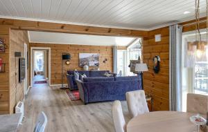 a living room with a blue couch and wooden walls at Lovely Home In Stryn With House A Panoramic View in Stryn