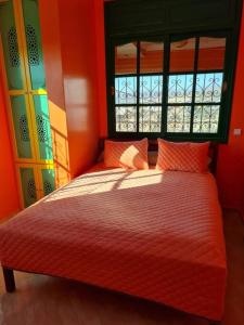 Tamraght Ou FellaにあるTamraght 3 Bedroom Apt with Oceanview 2.Levelのベッドルーム1室(オレンジ色の壁のベッド1台、窓付)