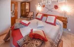 ein Schlafzimmer mit einem großen Bett mit roten und weißen Kissen in der Unterkunft Lovely Home In Moustiers-sainte-marie With Kitchen in Moustiers-Sainte-Marie