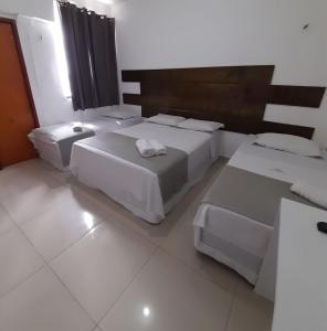 a room with two beds and two tables at Central Palace Hotel in Fortaleza
