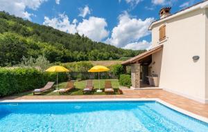 een villa met een zwembad en een patio met parasols bij Villa Dol in Buzet