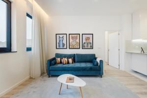 een woonkamer met een blauwe bank en een tafel bij GuestReady - Oz's Place Haven in Matosinhos