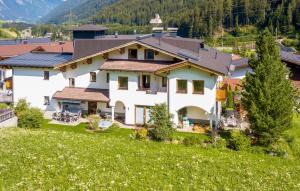 dom na wzgórzu z zielonym polem w obiekcie Stilvolle Ferienwohnung w mieście Sankt Anton am Arlberg