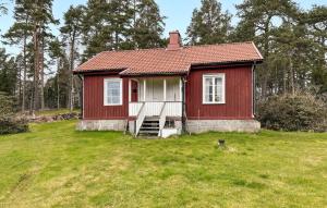 een klein rood huis in een grasveld bij Beautiful Home In ml With Kitchen in Åmål