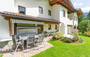 patio ze stołem i krzesłami przed domem w obiekcie Stilvolle Ferienwohnung w mieście Sankt Anton am Arlberg