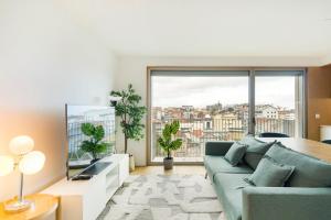 a living room with a couch and a large window at GuestReady - Central Park in Porto in Porto