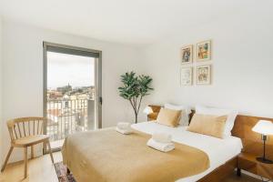 biała sypialnia z dużym łóżkiem i oknem w obiekcie GuestReady - Central Park in Porto w Porto