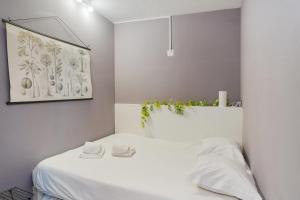 um quarto com uma cama branca com plantas por cima em GuestReady - An amazing stay in Heroismo no Porto